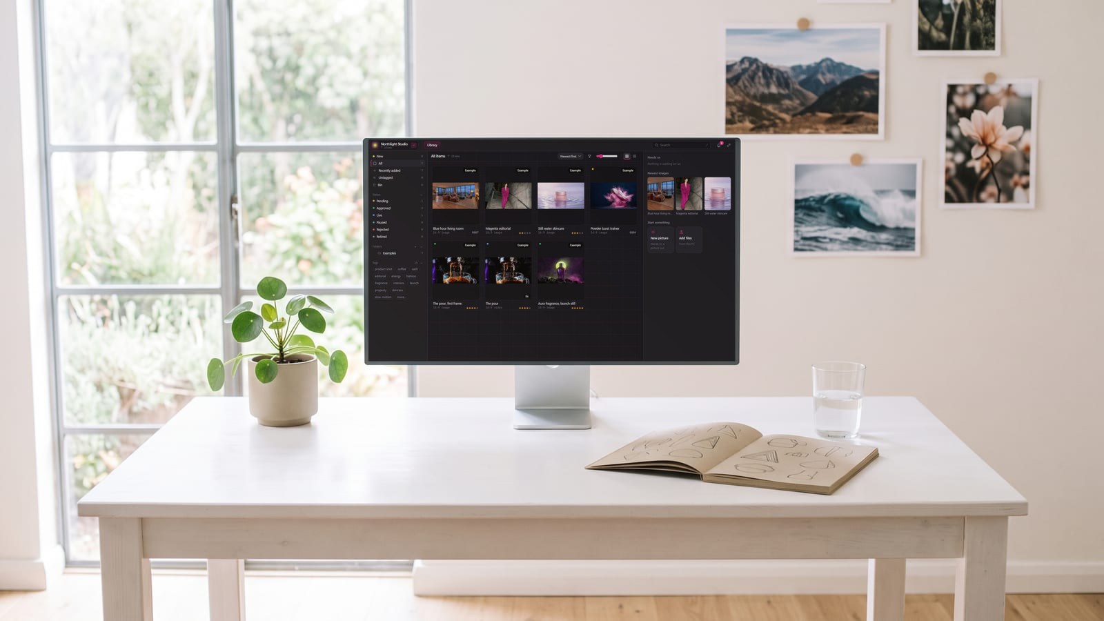 BosOn, a desktop app for Windows and Mac, on a monitor in a bright studio, showing a library of AI pictures and clips with ratings, statuses and tags